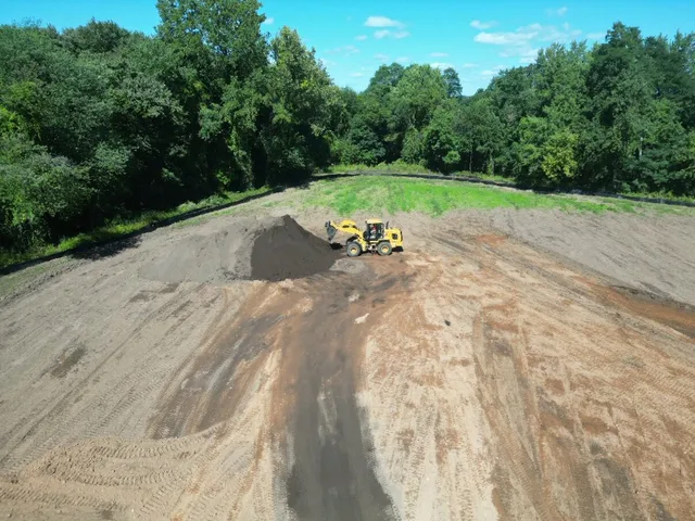 Drone view of a dozer spreading fill across a large graded area