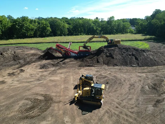 Drone view of a dozer working in front of the topsoil stockpile and screener