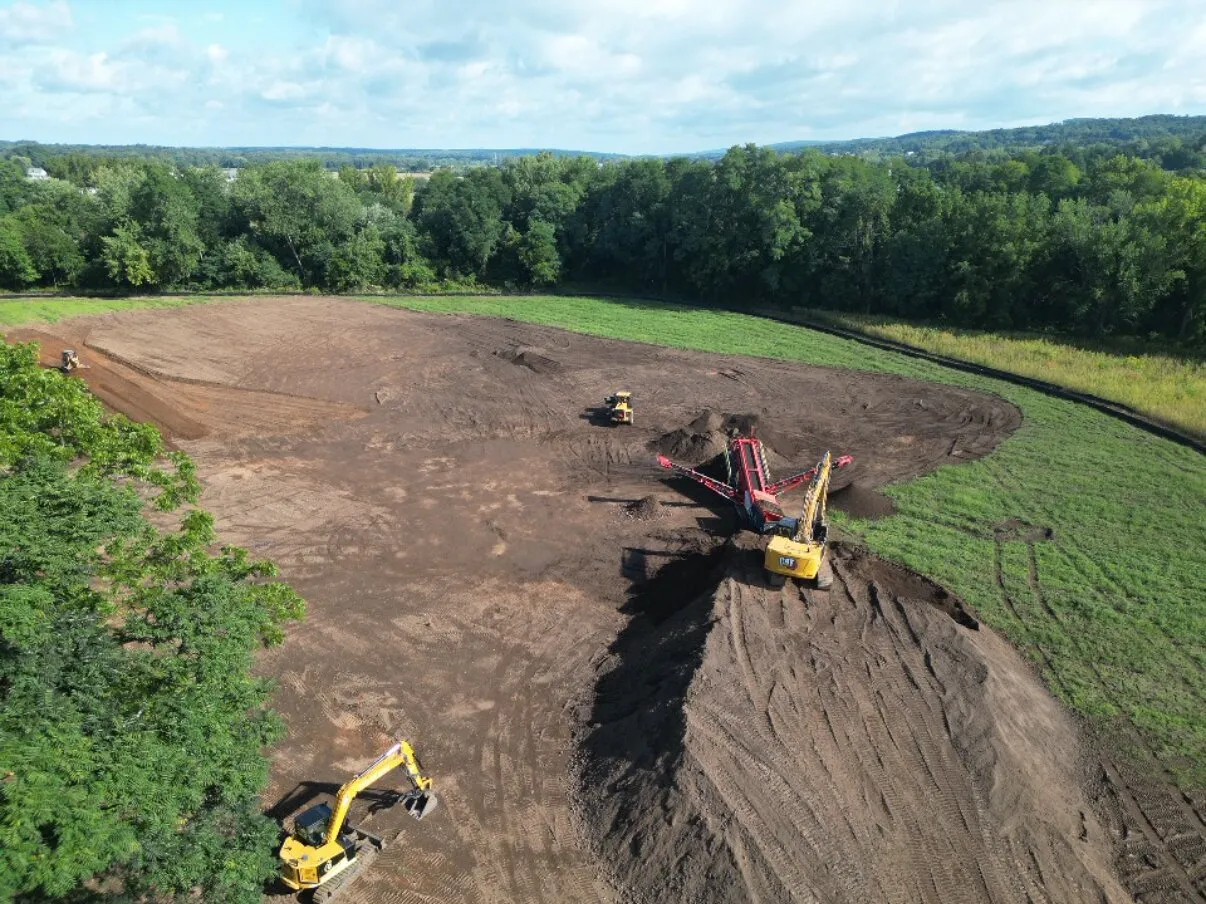 Drone view of the screened topsoil stockpile with the loader and screener at work