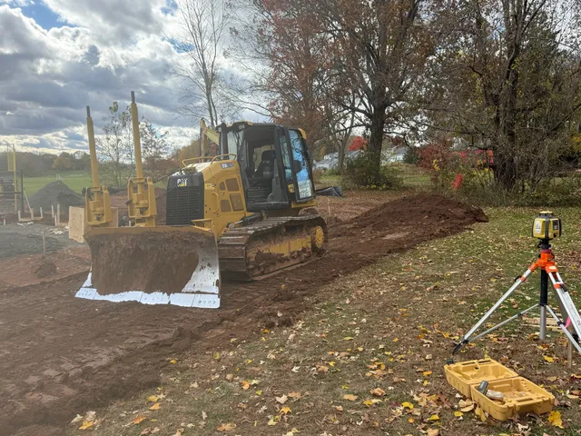 Dozer laser grading a field with the tripod receiver set on grade