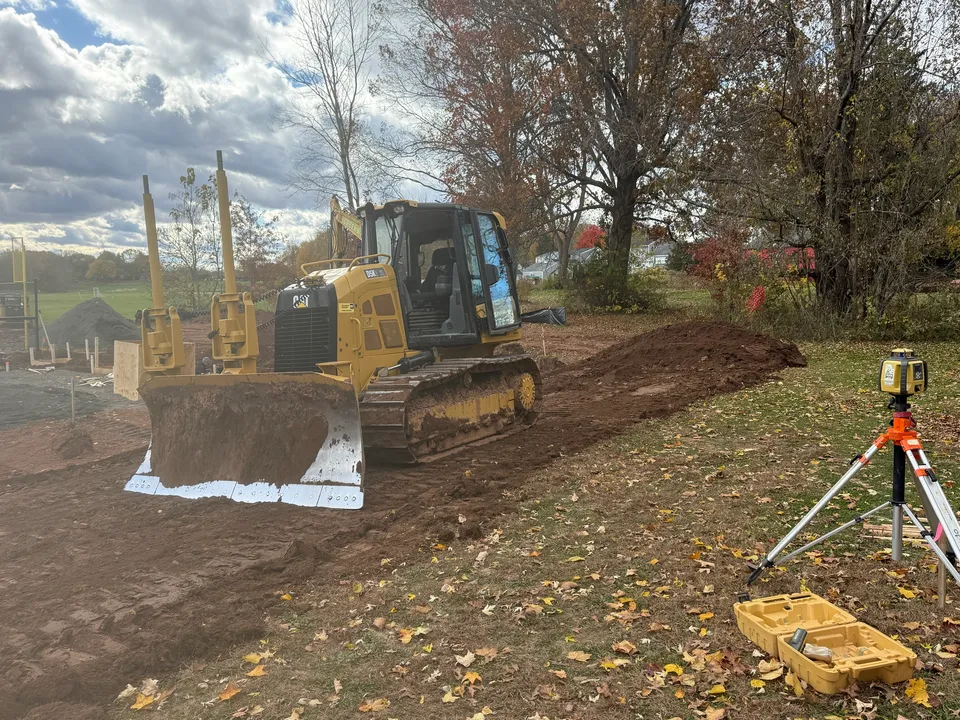 Dozer laser grading a field with the tripod receiver set on grade