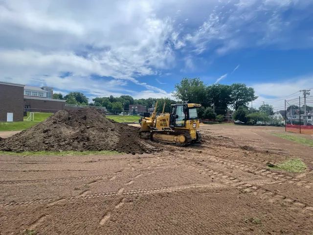 Dozer spreading a topsoil pile across a graded field