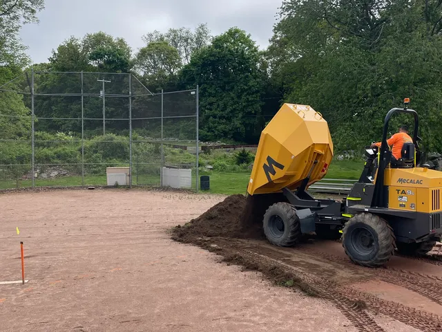 Tracked dumper hauling infield mix onto a ballfield