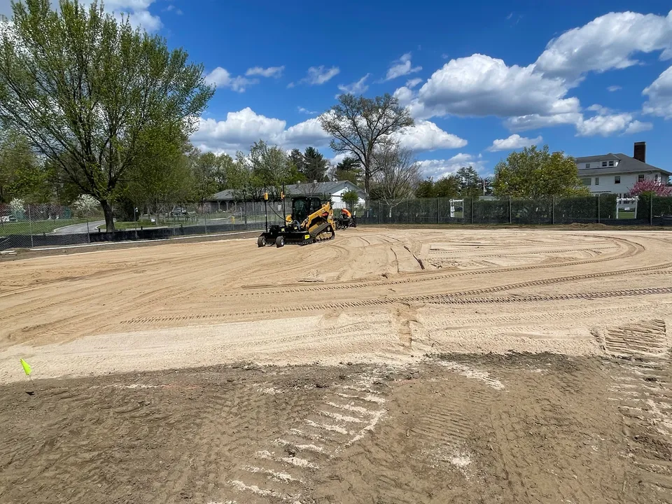 Skid steer finish grading a ballfield