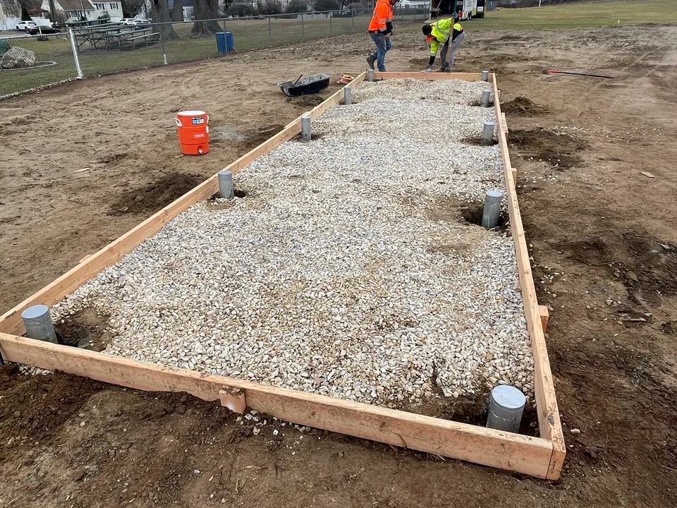 Gravel pad with drainage stubs set before the concrete pour