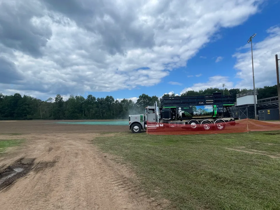 Hydroseed truck seeding a finished athletic field