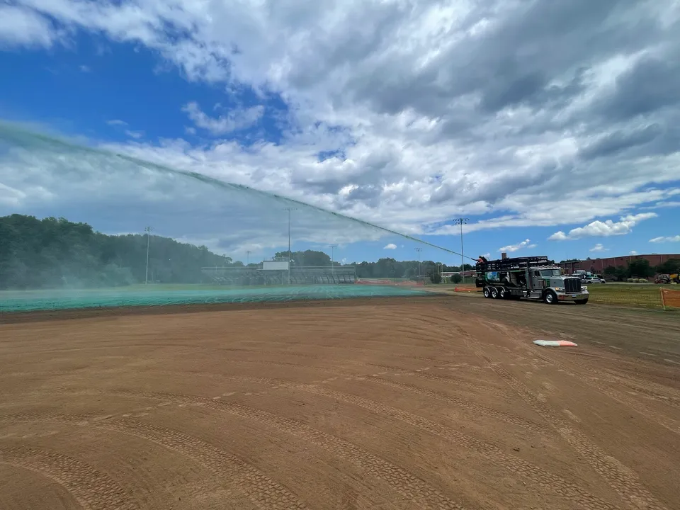 Hydroseed going down on a graded athletic field