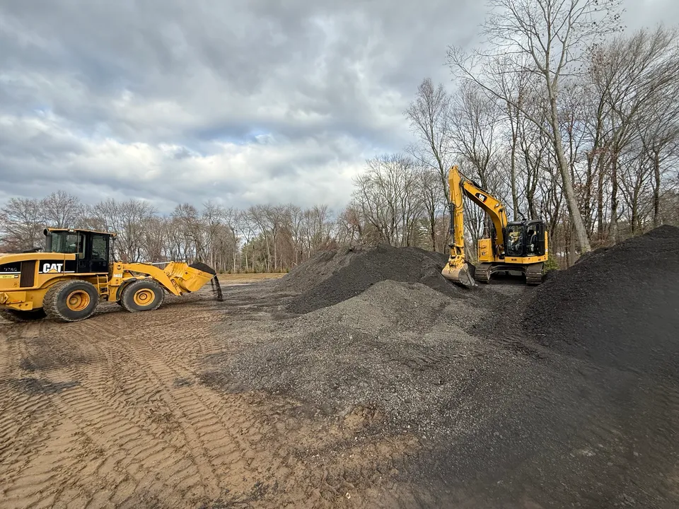 Loader and excavator working a gravel stockpile