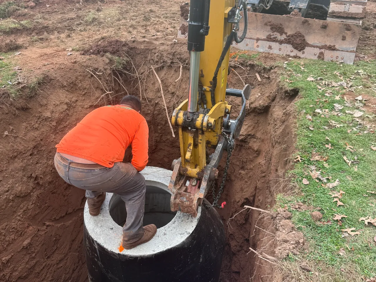 Lowering a precast manhole section into place