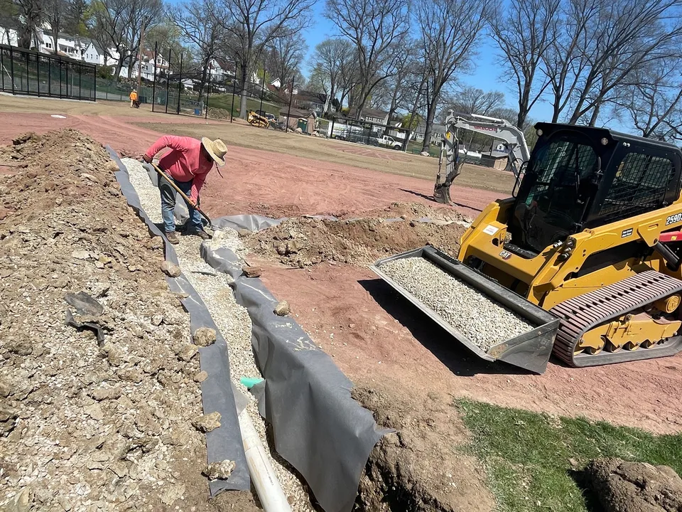 Drain pipe going into a trench with a skid steer