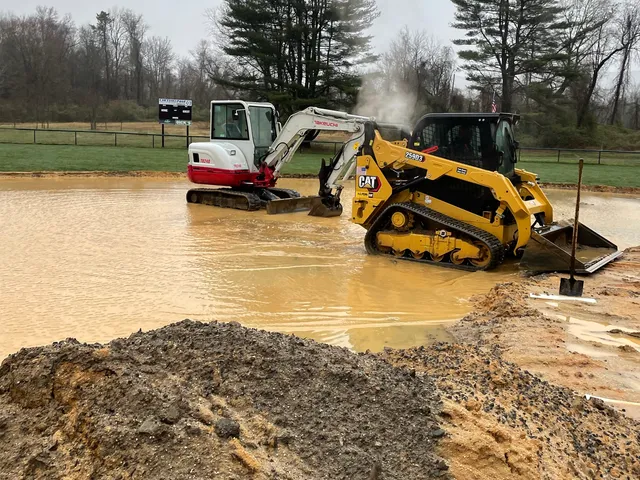 Skid steer and excavator working a wet excavation